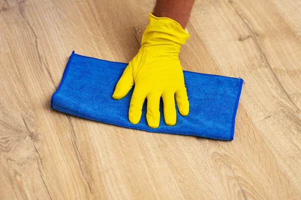 Gloved hand washing a laminate flooring with a wet cloth — Stock Photo, Image