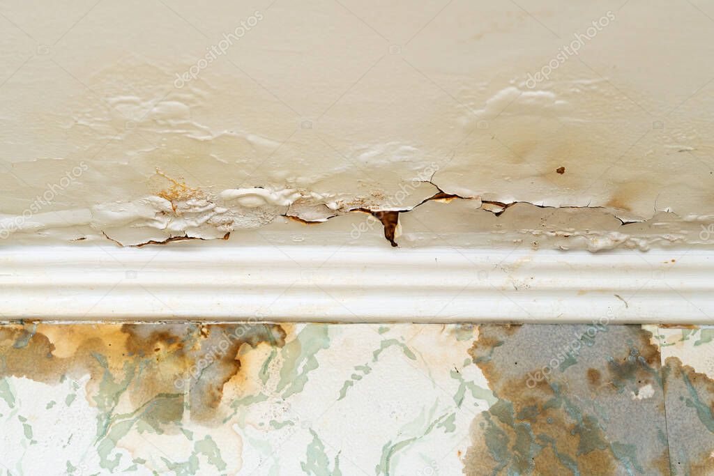 Cracked plaster on the ceiling after a water leak from the upper floor