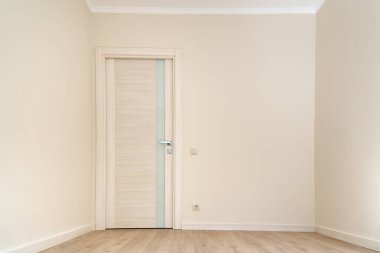 Modern boş oda, katı renkli duvar kâğıdı, katlı zemin ve yenilenmeden hemen sonra cam şeritli bir kapı.