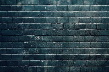 Güneş ışığıyla aydınlatılan eski siyah fayanslı duvar