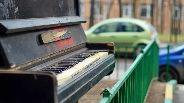 Разбитая фортепиано, брошенная на улице рядом с дорогой — стоковое фото