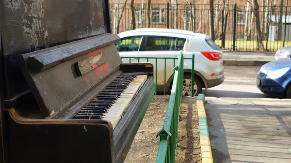 Vanha pianoforte hylätty ulkona lähellä tietä — kuvapankkivalokuva