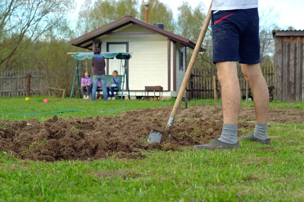 Young man digging the earth — Stock Photo, Image
