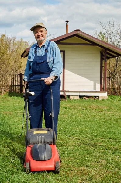 Un anciano cortando una hierba — Foto de Stock