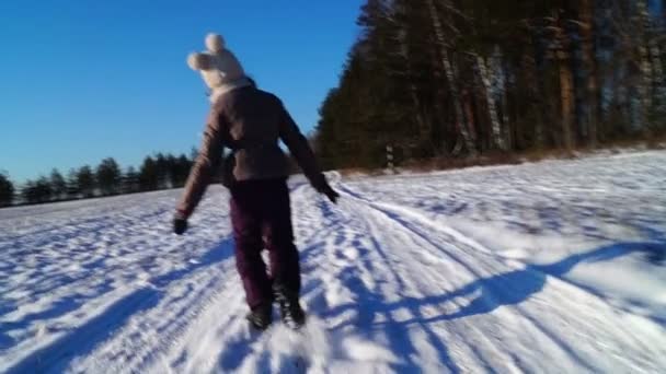 Tien - jarige meisje loopt langs de weg van de besneeuwde winter — Stockvideo