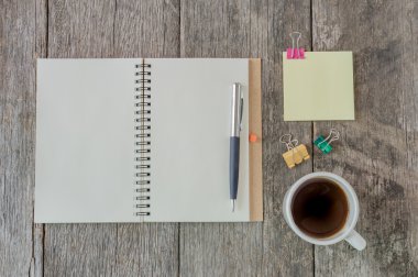 Kahve fincanı ve sarı no ile ahşap arka plan üzerine açık defter