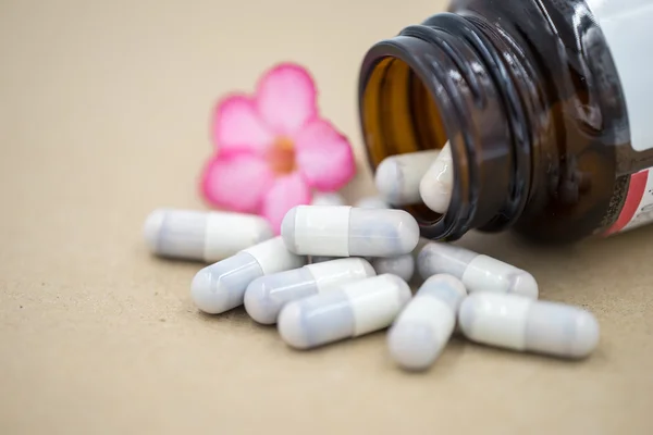 Herb capsules spilling out of a bottle. — Stock Photo, Image