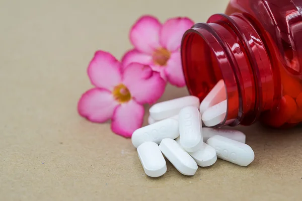 Herb capsules spilling out of a bottle. — Stock Photo, Image