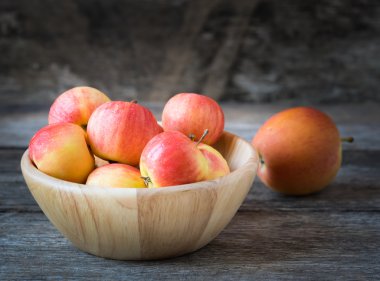 Ahşap arka plan ağaç bir kase içinde elma.