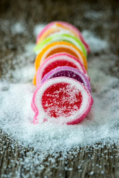 Gelée sucrée, fruits aromatisés, dessert aux bonbons coloré sur fond de bois . — Photo