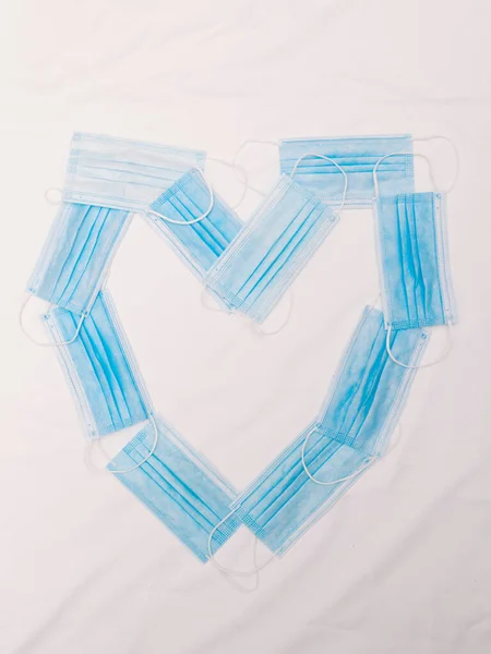Corazón Hecho Con Máscaras Quirúrgicas Azules Colocadas Encima Paño Blanco — Foto de Stock