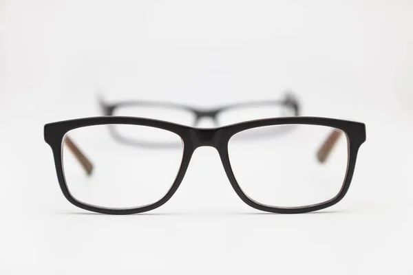白い表面に置かれた眼鏡の2組 最も近いものは焦点にあり 他のものは焦点を当てていません 背景は白 — ストック写真