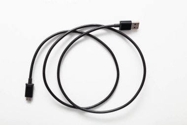 Beyaz arkaplanda izole edilmiş USB ve mikro USB bağlantıları olan siyah kablo.