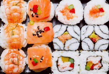 Pilav, balık, yosun, kabuklu deniz hayvanı, sebze ve yeşilliklerden yapılan farklı suşi çeşitleri. Tipik Japon mutfağı..