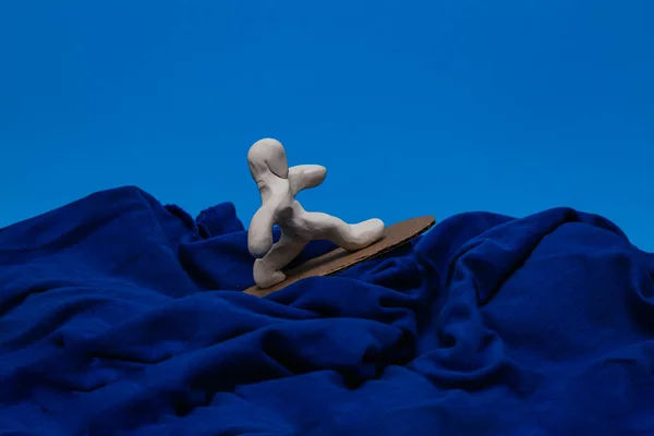 Μια Λευκή Πλαστική Κούκλα Που Σερφάρει Μπλε Φόντο Κούκλα Ισορροπεί — Φωτογραφία Αρχείου