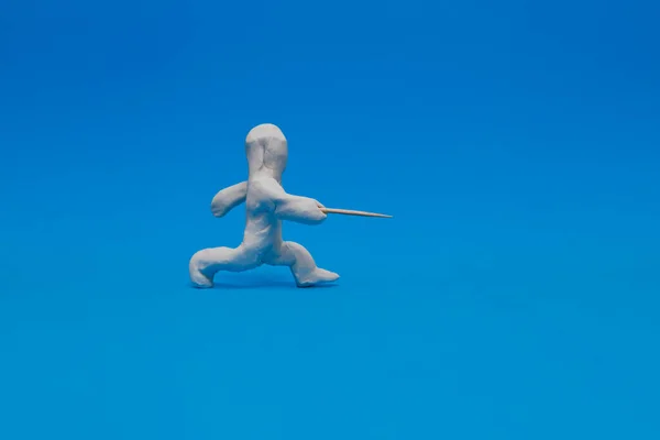 青い背景にフェンシングを練習白いプラスチックダミー ダミーは彼のホイルで推力を作っている — ストック写真
