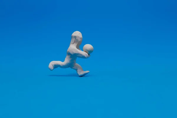 Белая Пластилиновая Кукла Практикующая Волейбол Синем Фоне Кукла Получает Мяч — стоковое фото