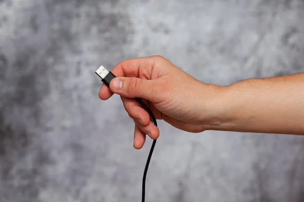 Mano Derecha Hombre Sosteniendo Cable Usb Negro Sobre Fondo Gris —  Fotos de Stock