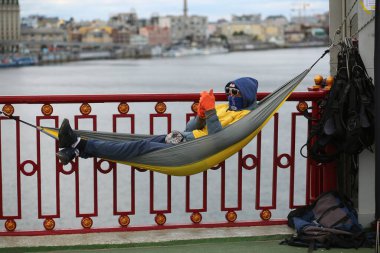Kyiv, Ukrayna - 18 Ekim 2020: Sporcu turist köprüdeki bir hamakta dinleniyor