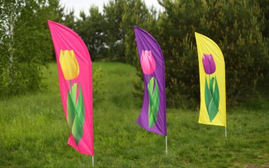 Parktaki çiçek tarhlarını işaretleyen lalelerle dolu bayraklar.