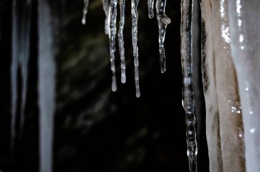 Buz saçakları kayadan sarkıyor, metin için yer, tasarım için şablon