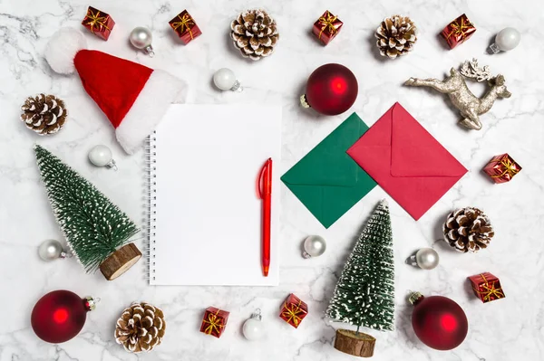 Boże Narodzenie płaski leżał: pusty notatnik z świąteczną dekoracją, Santa kapelusz, renifer, drzewo i kulki na marmurowym tle — Zdjęcie stockowe