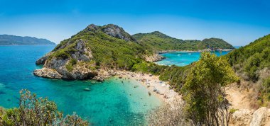 Yunanistan 'ın Korfu adasındaki Porto Timoni plajı. Yeşil dağların güzel panoramik manzarası, berrak deniz suyu, tenha Pirates Körfezi ve çifte taşlı plaj. Yaz tatili için ünlü bir yer.