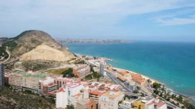 Alicante şehri üzerinde Postiguet plajı, Akdeniz, Serra Grossa dağı ve caddelerde hareket eden arabaların görüntüsü. İspanya 'nın Costa Blanca bölgesi yukarıdan