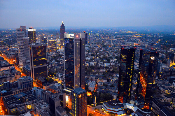FRANKFURT, GERMANY - APRIL 12: Frankfurt cityscape with illuminated office buildings on April 12, 2014. The financial district of Frankfurt with the main business buildings (skyscrapers).