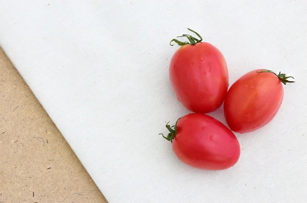 Alaca arka plan üzerinde üç domates — Stok fotoğraf