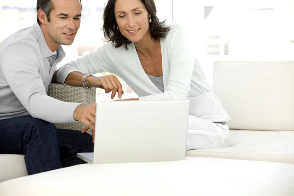 Średnim wieku pary za pomocą komputera w domu — Zdjęcie stockowe