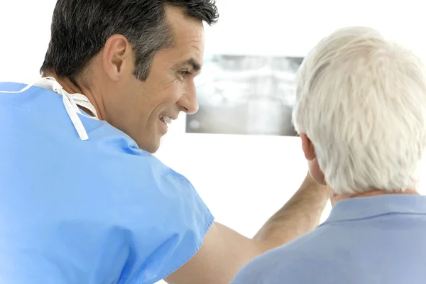 Surgeon showing x-ray image to senior patient — Stock Photo, Image