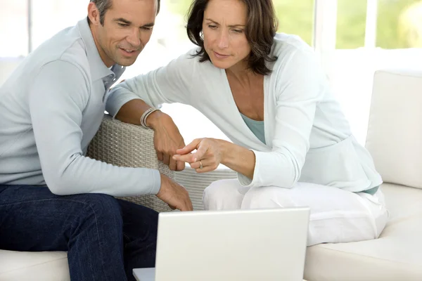 Pareja de mediana edad usando PC en casa —  Fotos de Stock