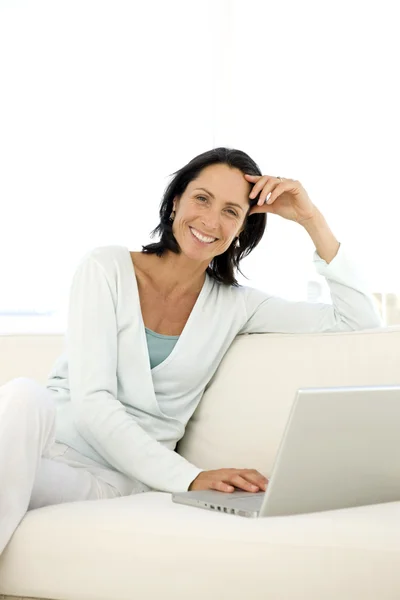 Middelbare leeftijd vrouw met behulp van PC thuis — Stockfoto