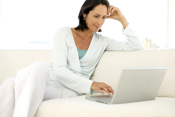 Kobieta w średnim wieku za pomocą komputera w domu — Zdjęcie stockowe