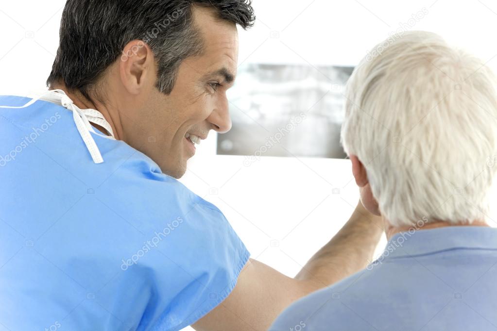 Surgeon showing x-ray image to senior patient