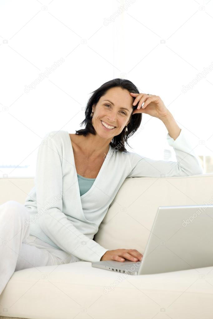Middle aged woman using pc at home