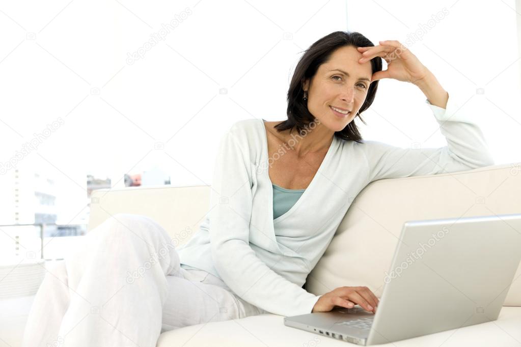 Middle aged woman using laptop at home