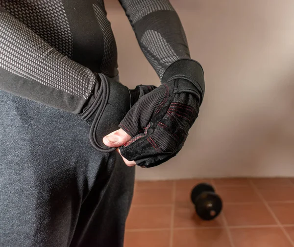 Kol egzersizleri için spor eldiven giyen bir adam. Konsept: fitness