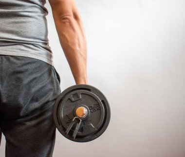 Dambılı bir adam, evde egzersiz yapıyor. Konsept: Evde fitness