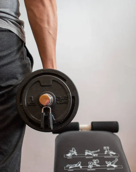 Dambılı bir adam, evde egzersiz yapıyor. Konsept: Evde fitness