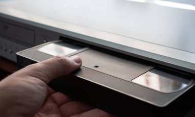 A person who places a VHS tape in the player.