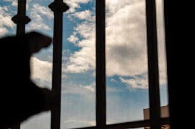 Erkek el, ev hapsi sırasında gökyüzüne dokunmaya çalışıyor.