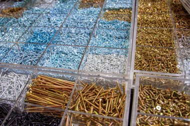 Çeşitli boyutlarda ve tiplerde bir yığın halinde düzenlenmiş bir sürü inşaat bağlayıcı, vida ve cıvata