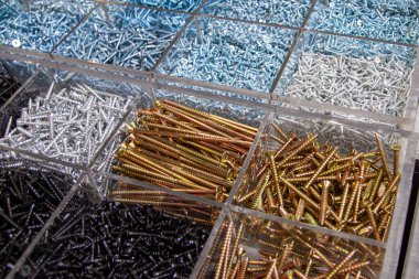 Çeşitli boyutlarda ve tiplerde bir yığın halinde düzenlenmiş bir sürü inşaat bağlayıcı, vida ve cıvata