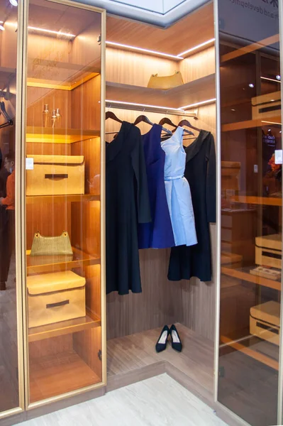 Ropa de mujer, vestidos, zapatos se mantienen en el armario moderno conveniente, limpio, armario organizado vista interior Fotos de stock