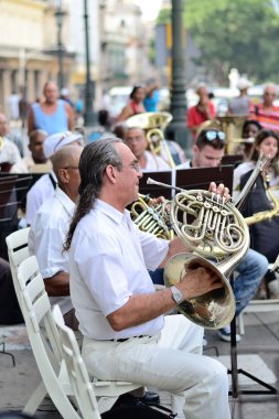 A musician with a french horn in an orchestra  in Havana, Cuba on May 10, 2013.. clipart