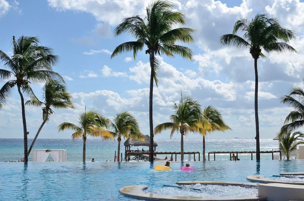 Ein Schwimmbad in Meeresnähe mit Palmen. — Stockfoto