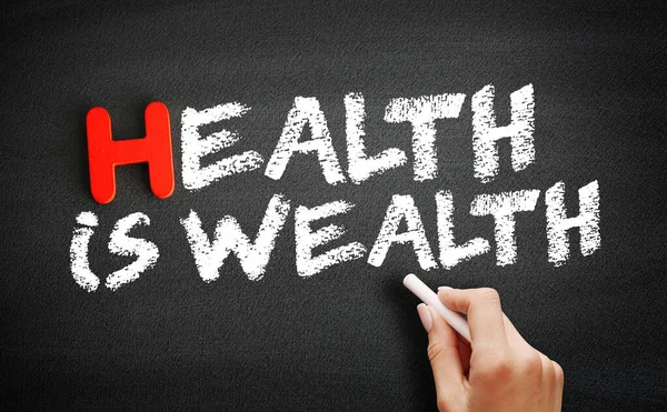 Hand writing Health is Wealth on blackboard, health concept background
