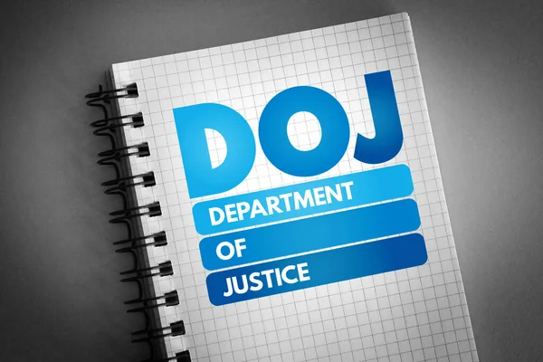 DOJ - Department of Justice acronym on notepad, concept background